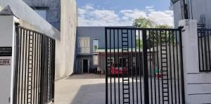 an open gate to a courtyard with a building at Pike Guest House in Dagupan