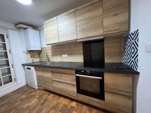 a kitchen with wooden cabinets and a black counter top at Maison en face du Marche Notre-Dame in Poitiers +23 photos
