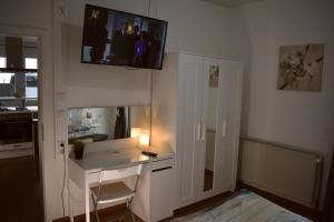 a room with a desk and a tv on the wall at Ferienwohnung Labradoodle in Dornum
