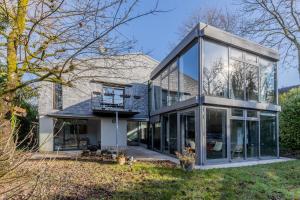 a house with glass doors and a balcony at Home sweet Lux - 8P - House & garden - 280n m2 in Lorentzweiler