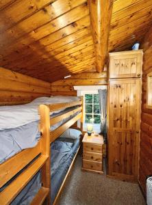 a bedroom with two bunk beds in a log cabin at Snowdonia Escape in Trawsfynydd