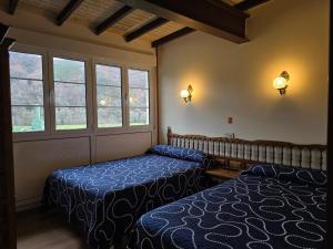 a bedroom with two beds and a window at Pensión La Unión in Trevías
