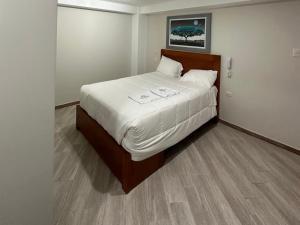 a bedroom with a large bed with white sheets at Hotel Altavista in Abancay
