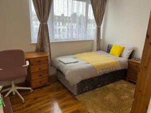 a bedroom with a bed and a desk and a chair at Maxismile Haven in Southend-on-Sea +21 photos