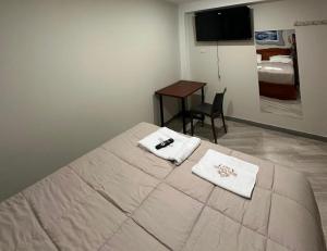 a bedroom with a bed with two towels on it at Hotel Altavista in Abancay +6 photos
