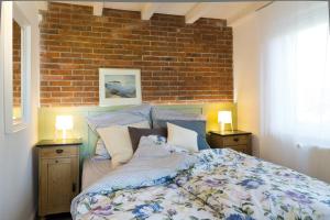 a bedroom with a bed and a brick wall at Ferienhaus Clara in Wardenburg
