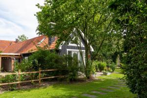 a house with a fence and a tree at Ferienhaus Clara in Wardenburg