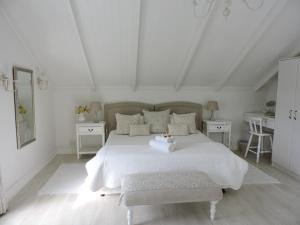 a white bedroom with a white bed and two tables at Riverlea in Cape Town +27 photos
