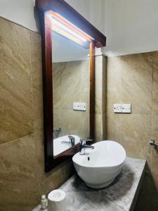 a bathroom with a white sink and a mirror at Sigiriya Yahana in Sigiriya