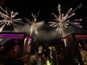 a group of people watching fireworks in the sky at Yellow Dream B&B in Torre Melissa
