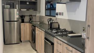 a kitchen with a stove and a refrigerator at Upendo Apartment 2 Bedroom in Tilisi in Gatimu