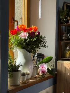 a vase filled with flowers sitting on a shelf at Viandanti, Artisti e Sognatori in Comano
