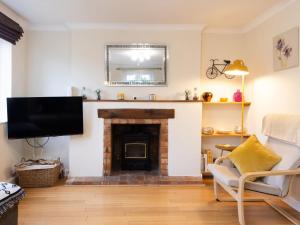 a living room with a fireplace and a tv at White Stones in Burford