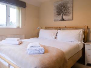 a bedroom with a bed with towels on it at White Stones in Burford