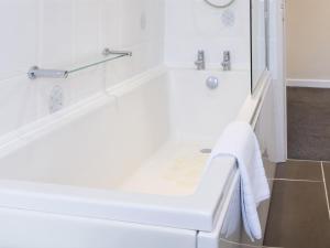 a white bath tub in a bathroom with a shower at White Stones in Burford +20 photos