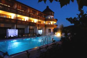 a large building with a swimming pool at night at Wellness Hotel Bayerischer Hof in Rimbach