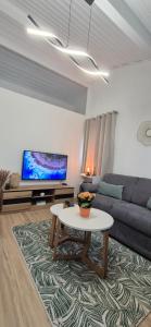a living room with a couch and a table at Au calme, parking gratuit,proche centre Thonon les bains in Allinges