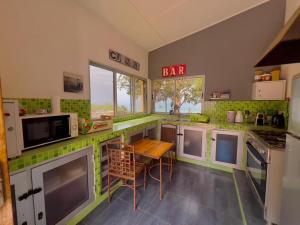 a kitchen with green tiles on the counters and a table at Villa La beauté luxueuse in Rufisque