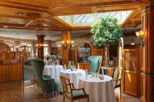 a restaurant with white tables and green chairs at Wellness Hotel Bayerischer Hof in Rimbach