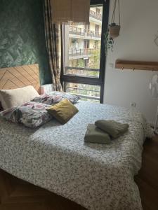 a bed with two pillows on it with a window at Les Chambres de David in Paris +3 photos