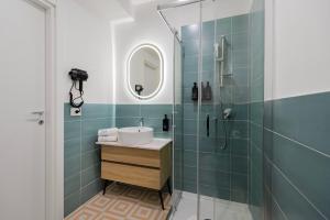 a bathroom with a shower with a sink and a mirror at Enia Rooms in Nola