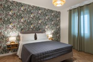 a bedroom with a large bed with a floral wallpaper at Enia Rooms in Nola