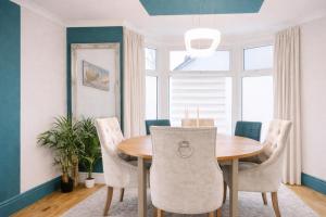 a dining room with a wooden table and chairs at Walk to Town, Parking, Family Home, drive to beach in Bridgend +45 photos