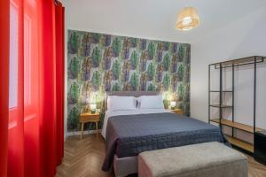 a bedroom with a bed and a red wall at Enia Rooms in Nola