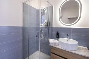 a bathroom with a sink and a shower at Enia Rooms in Nola