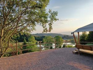 a bench and a fence with a view of a river at Coqslitscaux in Colleville