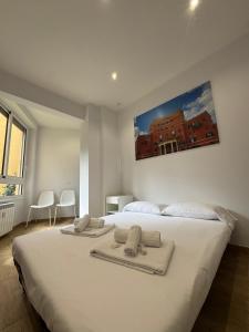 a bedroom with a large white bed with towels on it at Suite Rooms Garbatella in Rome +30 photos