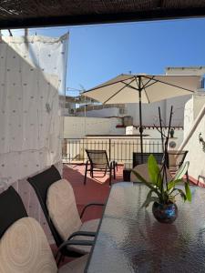 a patio with a table and chairs and an umbrella at Mil House in Cómpeta +8 photos