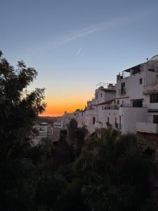 a sunset view of a city with white buildings at Mil House in Cómpeta