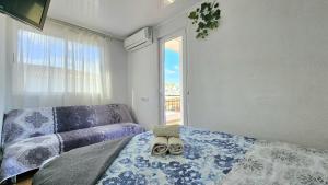 a bedroom with a bed and a couch and a window at GOLDEN TOWER pensión Auto Check-in in Gandía +53 photos