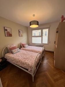 a bedroom with two beds and a window at Centre ville 2 chambres 4 voyageurs Tarif long séjour in Valenciennes