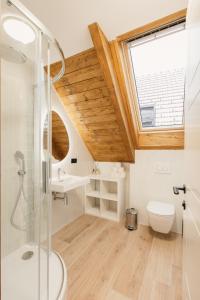 a bathroom with a shower and a toilet and a window at Neobyčejný Sklep in Pavlov +58 photos