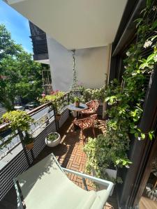 a balcony with a table and chairs and plants at Les Chambres de David in Paris