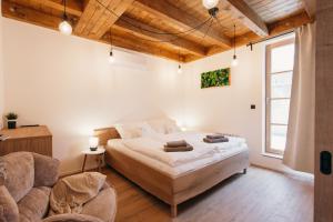 a bedroom with a large bed and two chairs at Neobyčejný Sklep in Pavlov