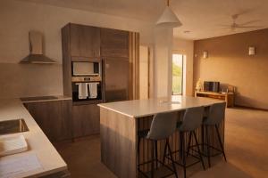 a kitchen with a island with bar stools at Sunset Haven in Flic-en-Flac +2 photos