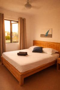 a bedroom with a large bed with white sheets and a window at Sunset Haven in Flic-en-Flac