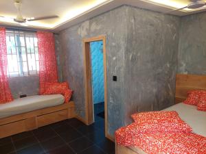 a bedroom with two beds and a door in it at Dizzy Lizzies Beach House Resort in Kokrobite