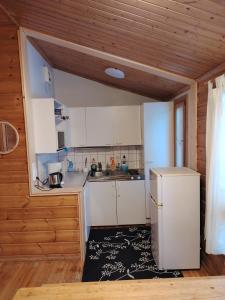 a kitchen with white cabinets and a refrigerator at Riihitupa 10 in Muurame