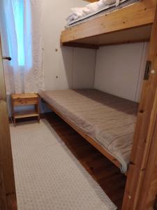 a bunk bed in a small room with a window at Riihitupa 10 in Muurame