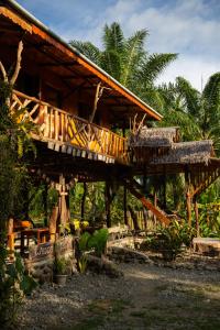 atropical house with a wooden floor and a balcony at La Capanna Sumatra Ecovillage in Timbanglawang +53 photos