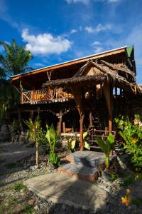 a building with a roof with some plants in front at La Capanna Sumatra Ecovillage in Timbanglawang