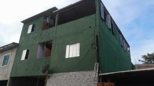 a green building with windows on the side of it at Casa de adao in Guarujá