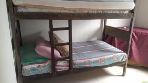 a set of bunk beds with a seat on top at Casa de adao in Guarujá