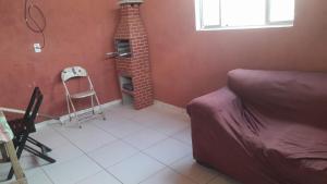 a living room with a brick fireplace and a couch at Casa de adao in Guarujá