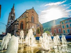 a water fountain in front of a church at La soie in Allevard +9 photos