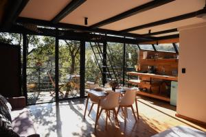 a kitchen and dining room with a table and chairs at Cabaña Gokotta, Punta del Bosque in Huasca de Ocampo